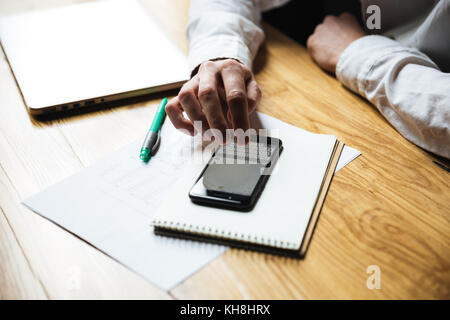 Top view of mans hand texting message on smartphone Stock Photo