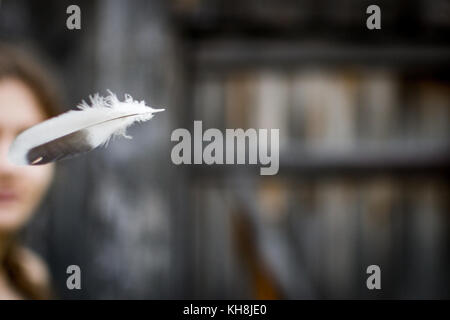 flying feather, the woman in the background Stock Photo