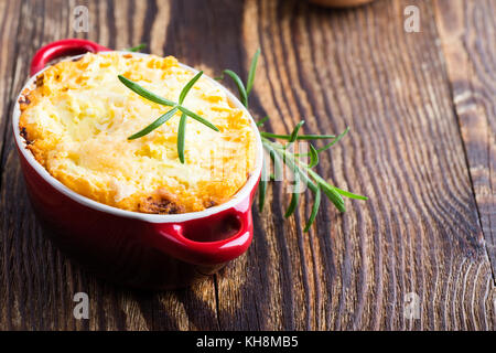 Shepherd's pie, traditional British dish with  minced meat and mashed potato on rustic wooden table Stock Photo