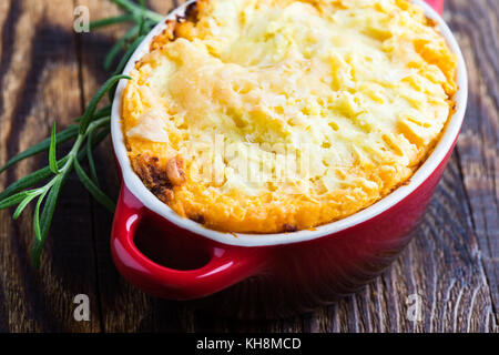 Shepherd's pie, traditional British dish with  minced meat and mashed potato on rustic wooden table Stock Photo