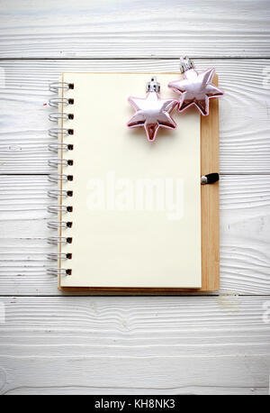 holiday decorations and notebook on white wood background Stock Photo