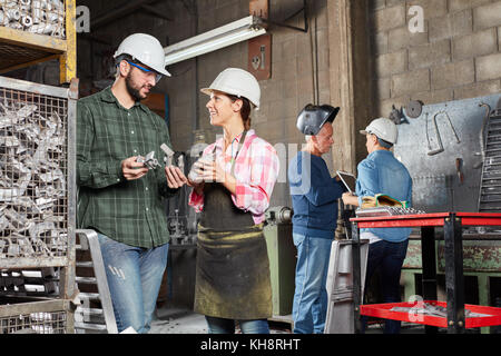 Metalworking workshop with two young apprentice in metallurgy factory Stock Photo