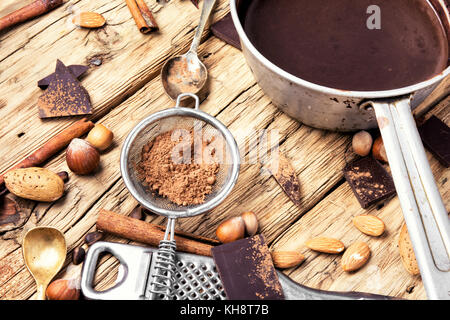 bowl with melted hot chocolate, cocoa beans, nuts and spices Stock Photo