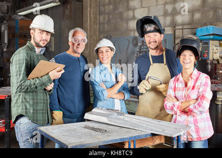 Metalworker team as a group in metallurgy workshop Stock Photo