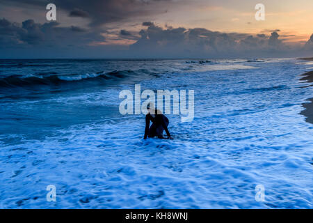 Puri beach with silhouette woman at the time of dawn Stock Photo - Alamy