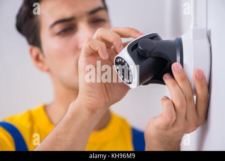 Contractor installing surveillance CCTV cameras in office Stock Photo