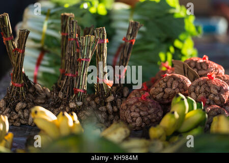 Bunches and bags of monkey nuts on a stall in Port Vila Fruit and Vegetable Market, late afternoon light. Vanuatu. Stock Photo
