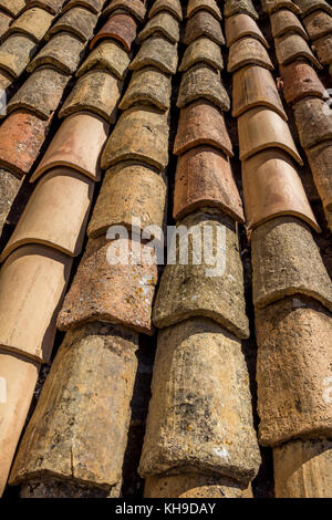 Neatly aligned rows of terracotta roof tiles, Dubrovnik's Old City. Several new tiles show aging of older ones. Small depth of field creates interest Stock Photo