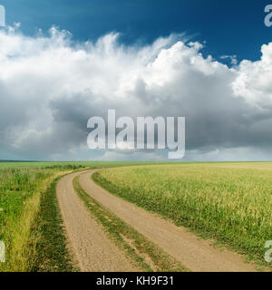 dirty road in fields and low clouds on horizon Stock Photo - Alamy
