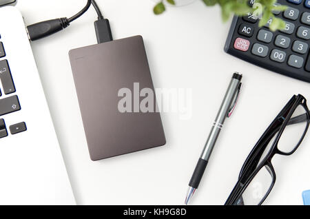 External backup disk hard drive connected to laptop. hard drive backup disk external computer data usb concept Stock Photo