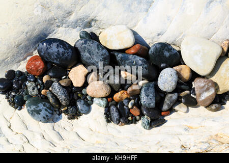 Multi coloured pebbles in a worn cleft in the chalk at Governor’s beach, Limassol, Cyprus Stock Photo