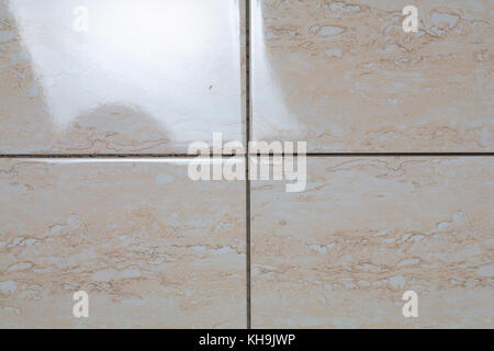 industrial construction worker installing small ceramic tiles on bathroom walls and applying mortar with trowel Stock Photo