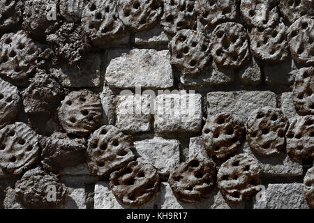 Stone wall made of massive gray bricks, with stuck cakes of manure of cows, fuel for stoves. Stock Photo