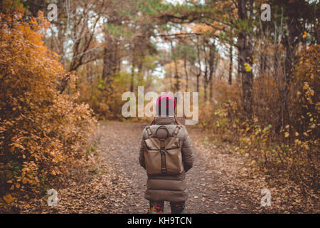Young woman in casual wear standing in autumn forest. Stock Photo