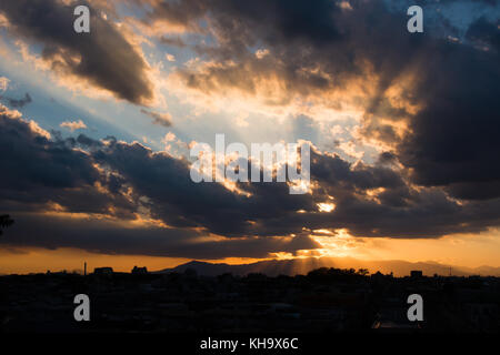 Sunset behind clouds Stock Photo