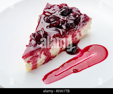 Slice of cheesecake with cherry jam on white plate  Closeup view Stock Photo