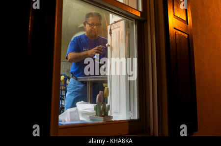 Arturo Suarez, East Cooper Meals on Wheels volunteer, makes coffee for other volunteers Oct. 10, 2016. The Meals on Wheels team's goal is to deliver meals to homebound residents in the area regardless of age or income free of charge. With the recent storms, residents have been left either stranded or unable to leave their homes to get food. (U.S. Air Force photo by Senior Airman Erin Babis) Stock Photo