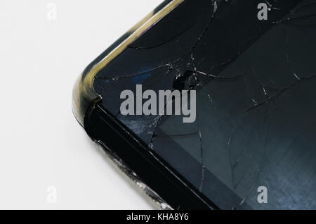 Close up on the upper corner of a smartphone with the glass broken of the screen. Stock Photo
