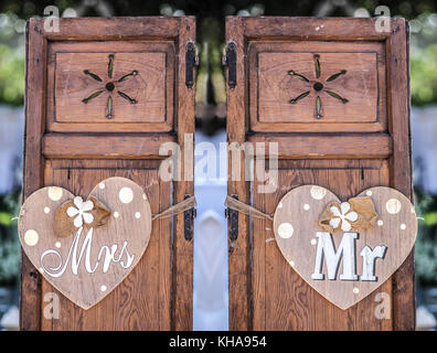 Old wooden shutter windows with hanging hearts for Mrs and Mr. Vintage decoration for weddings Stock Photo