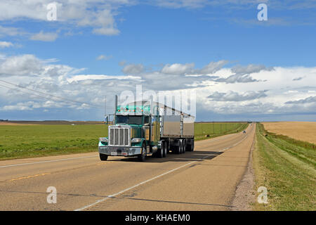 Truck drives on straight road, Alberta, Canada Stock Photo