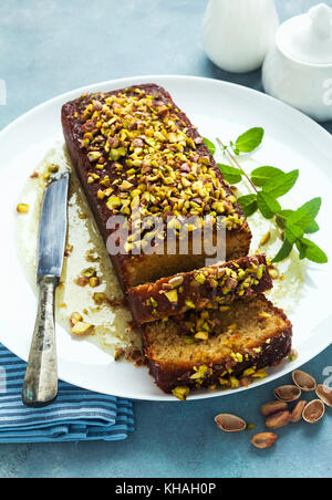 Cake, tea loaf with yogurt, cardamom and pistachios . on blu background Stock Photo