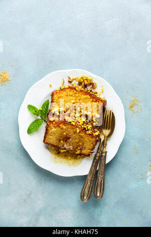 Cake, tea loaf with yogurt, cardamom and pistachios . on blu background Stock Photo
