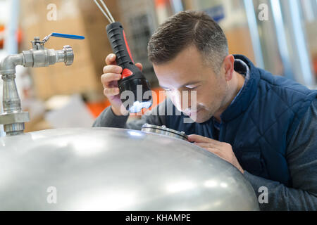 man looking through a stainless container Stock Photo