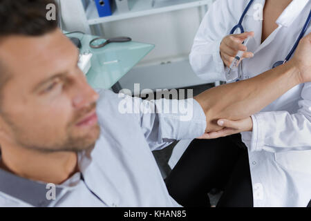 Man having injection in arm Stock Photo