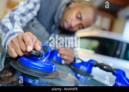 vehicle glazier using suction to remove the windshield Stock Photo