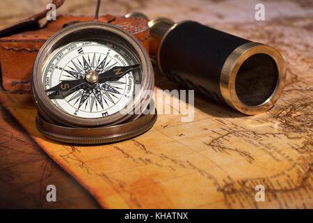 Brass compass and telescope on a map Stock Photo