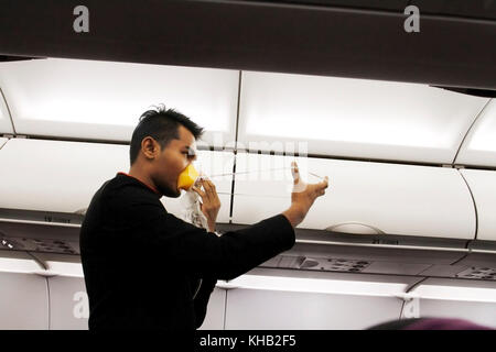 A steward demonstratiing safety procedure before takeoff..man Stock Photo