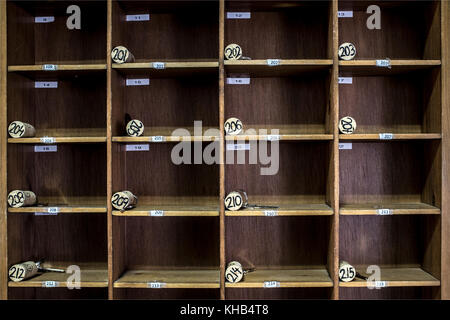 Vintage rural hotel front desk key rack with numbered corks. Focus on the top row of keys. Rural tourism concept Stock Photo