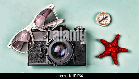 Ancient camera, sunglasses, old compass and starfish on a blue background. The concept: travel, vacation, active leisure, sea voyages. Stock Photo