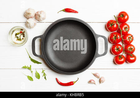 Cooking ingredients vegetables around the empty frying pan with copy space. Top view, flat lay. Stock Photo