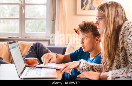 Two students sitting in front of a laptop, learning on the computer, Munich, Germany Stock Photo