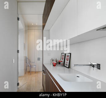 interiors shots of a modern kitchen in the foreground the sink with tap the floor is made of wood Stock Photo