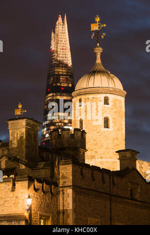 London's old and new architecture with the Shard skyscraper towering behind the floodlit Tower of London at dusk. Stock Photo