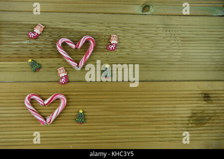 Christmas food photography picture with red white stripe candy cane sweets in love heart shape with cute iced decorations on wooden table Stock Photo