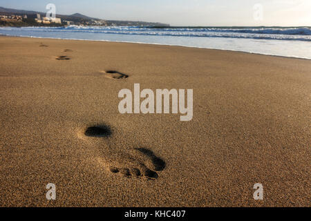 Solitary footprints in the sand - one person's footsteps on a clean beach at the seaside, Playa del Ingles coast and sea, Gran Canaria, Canary Islands Stock Photo