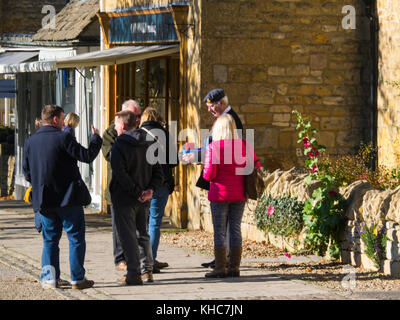People buying a poppy from a British Legion poppy seller in picturesque village Broadway Worcestershire England UK Stock Photo