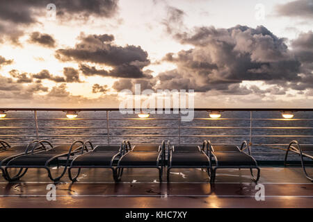 Sunbeds on cruise ship with cloudy sky Stock Photo
