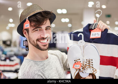 Happy young man shopping by fashion with 50% off discount Stock Photo