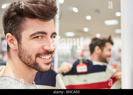 Young man as a customer shopping for fashion in the mall Stock Photo