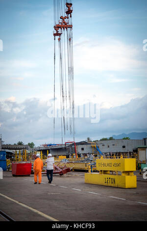 Two engineers walking alongside ship blocks in dockyard. Camranh shipyard. Vietnam Stock Photo