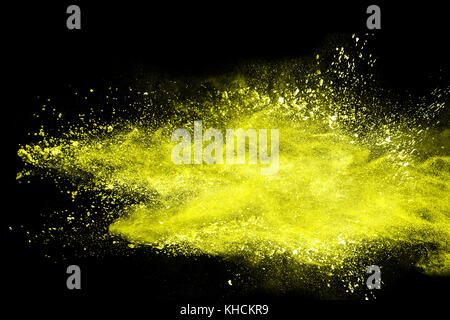 abstract yellow dust explosion on  black background.abstract yellow powder splattered on dark  background. Freeze motion of yellow powder splash. Stock Photo
