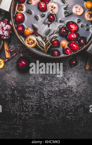 Mulled wine or punch in cooking pot  on dark vintage background, top view, border Stock Photo