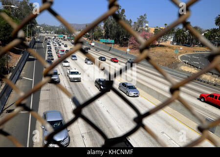 View through metal fence of cars looking down from a Sunset Blvd bridge onto the Hollywood Freeway in Los Angeles California USA   KATHY DEWITT Stock Photo