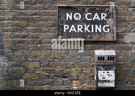 Brick masonry wall with a vintage 'No Car Parking' sign. Landscape format. Vintage look. Stock Photo