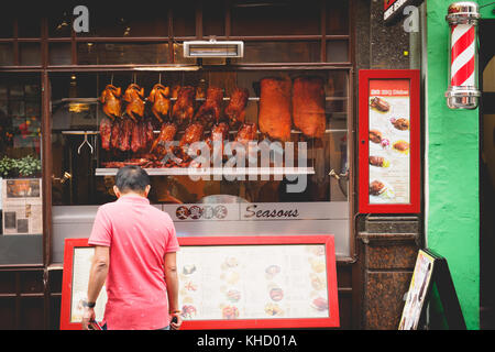 Crispy ducks hanging in a Chinese restaurant window in Chinatown. London, 2017. Landscape format. Stock Photo