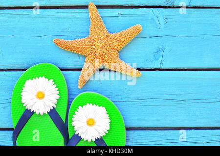 pair of flip-flops on blue wooden background and starfish Stock Photo